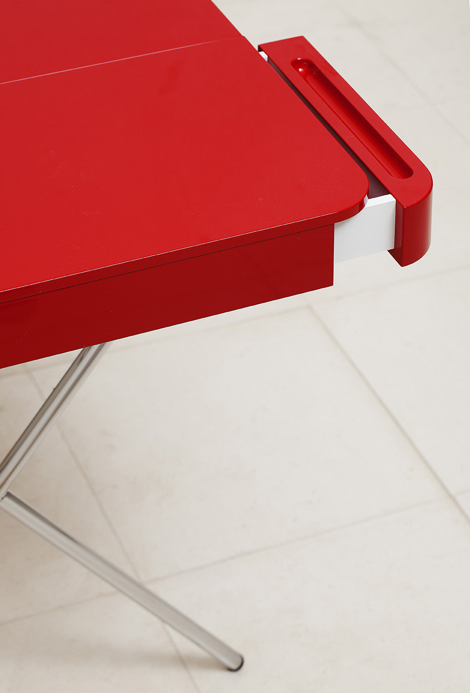 Vue plongeante sur le tiroir ouvert du bureau Cosimo laqué rouge brillant