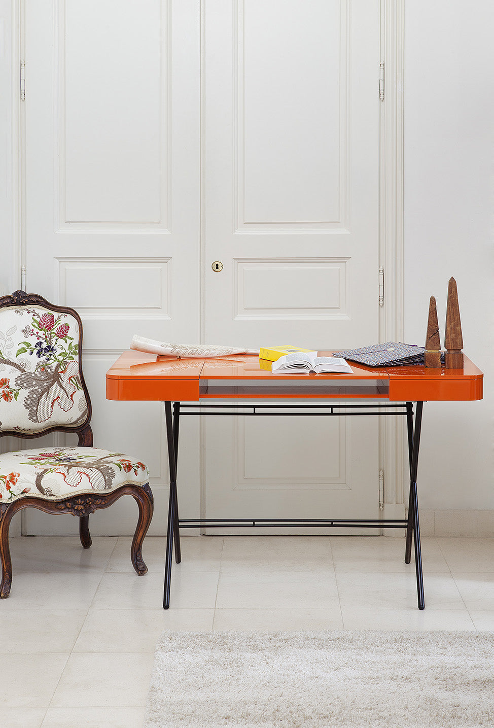 Bureau Cosimo laqué orange brillant dans un intérieur parisien, avec un fauteuil classique