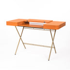 Bureau Cosimo laqué orange brillant, tablette ouverte, piètement doré, vue de trois quarts